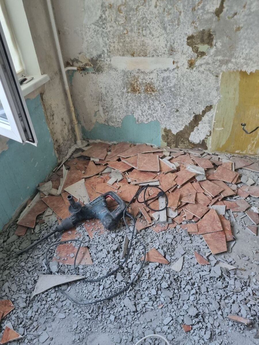 Vybouraný obklad a suť na podlaze koupelny při bouracích pracích