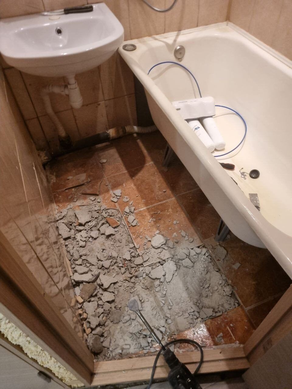 Demontáž staré vany a dlažby v koupelně před rekonstrukcí
