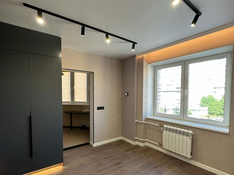 Obývací pokoj s kolejnicovými bodovkami a LED páskou pod nábytkem