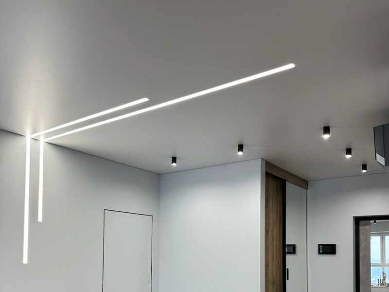 Strop se zapuštěnými lineárními LED svítidly v bytě po rekonstrukci v Praze